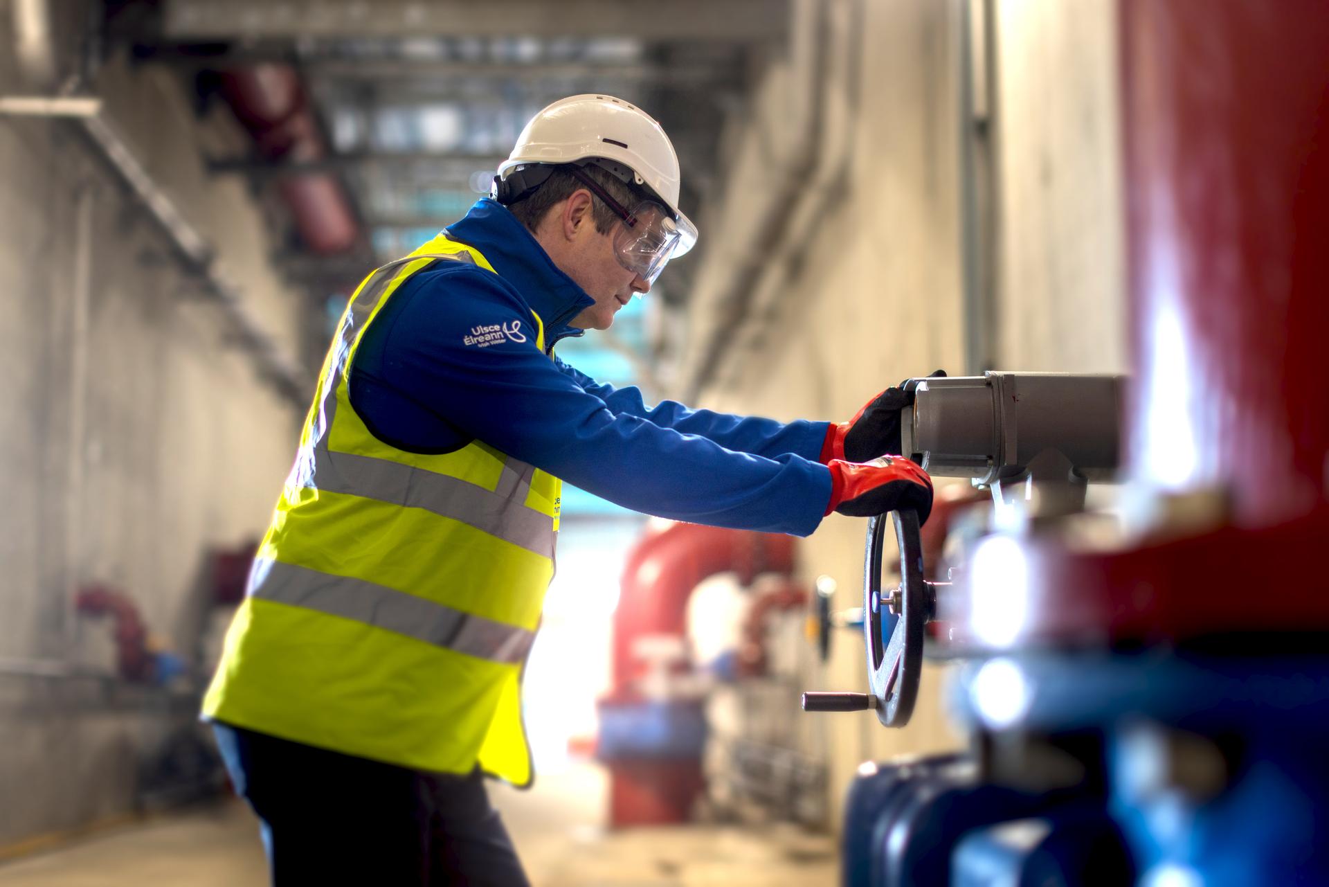 Uisce Éireann engineer turning a water valve