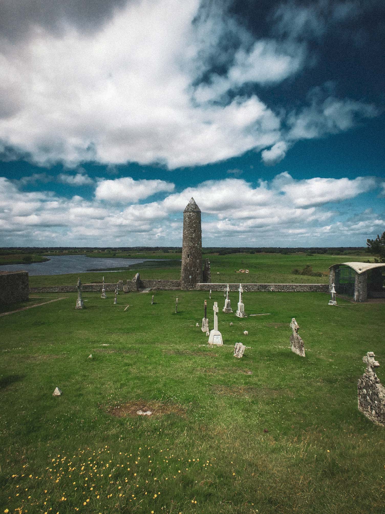 Graveyard with a round tower beside a lake