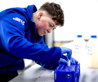 UÉ employee testing samples in a lab