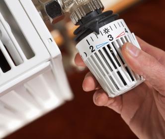 A person changing the radiator dial