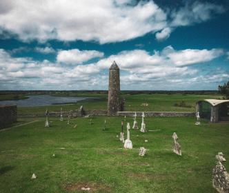 Graveyard with a round tower beside a lake